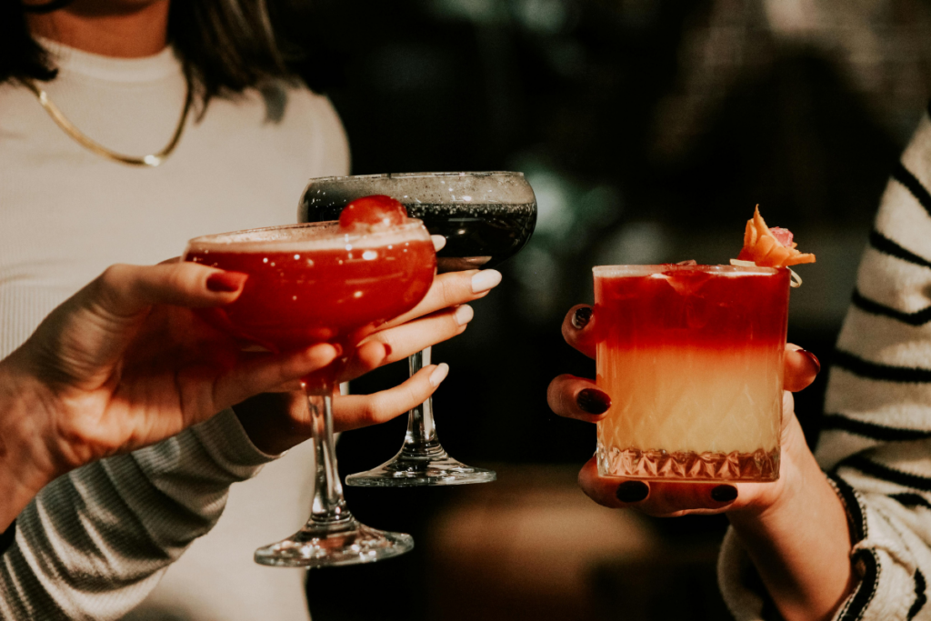 Erilaisia drinkkejä ja cocktaileja pidetään käsissä.