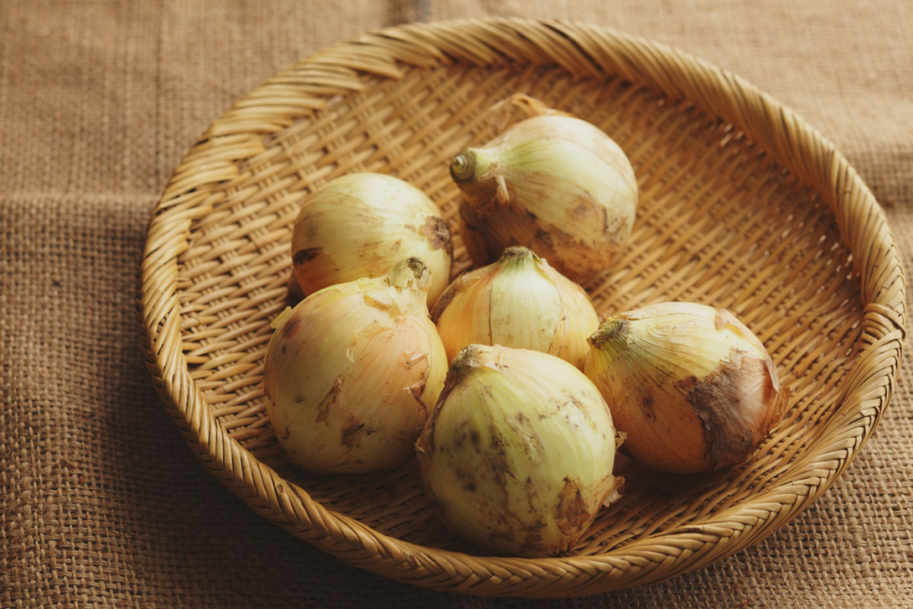 Kuusi keltasipulia korissa pöydällä. 