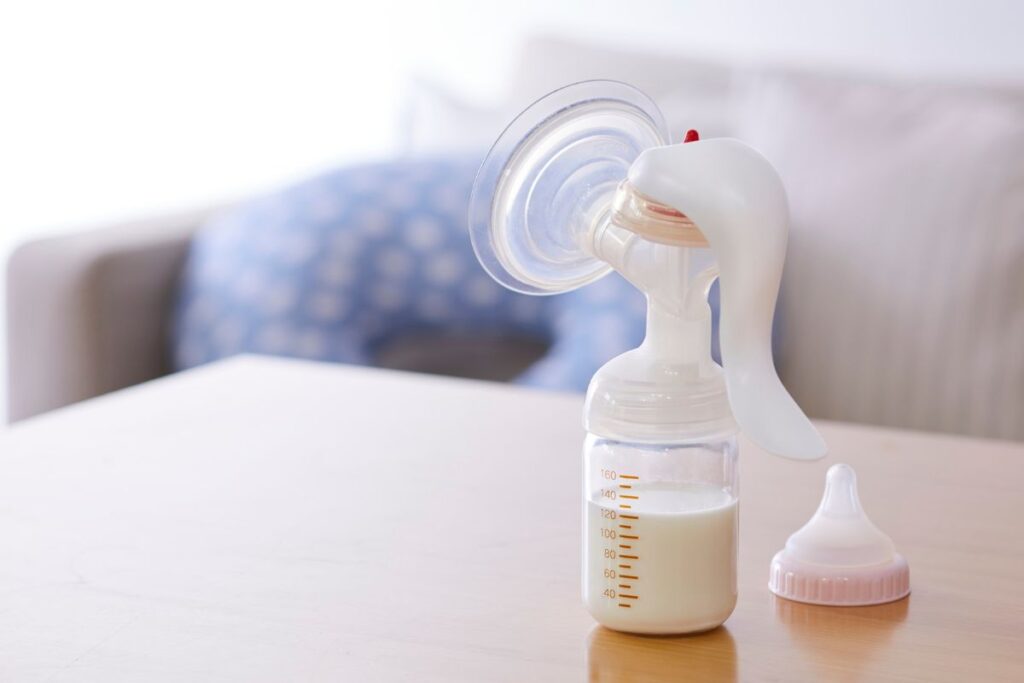 Rintapumppu ja tuttipullo, jossa on maitoa, pöydällä kotona.