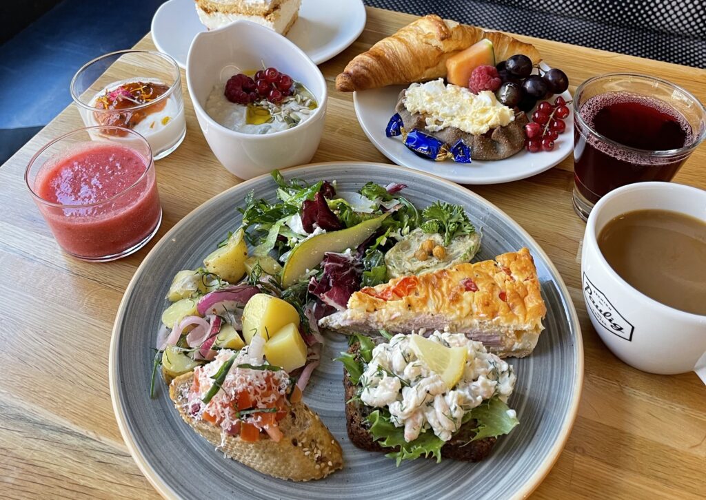 Bakery Cafen runsas brunssi useista annoksista ja juomista puupöydällä.