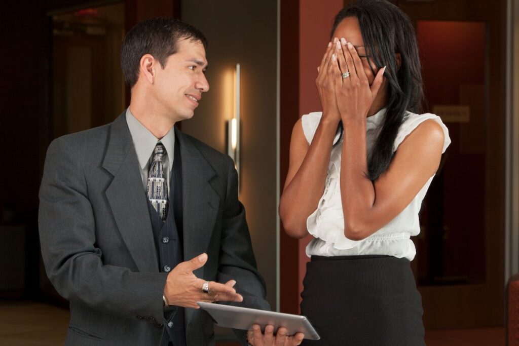 Mies näyttää tyytyväisenä itseensä naiselle jotain tabletilta ja nainen painaa kädet käsiään vasten selkeästi kiusaantuneena. 