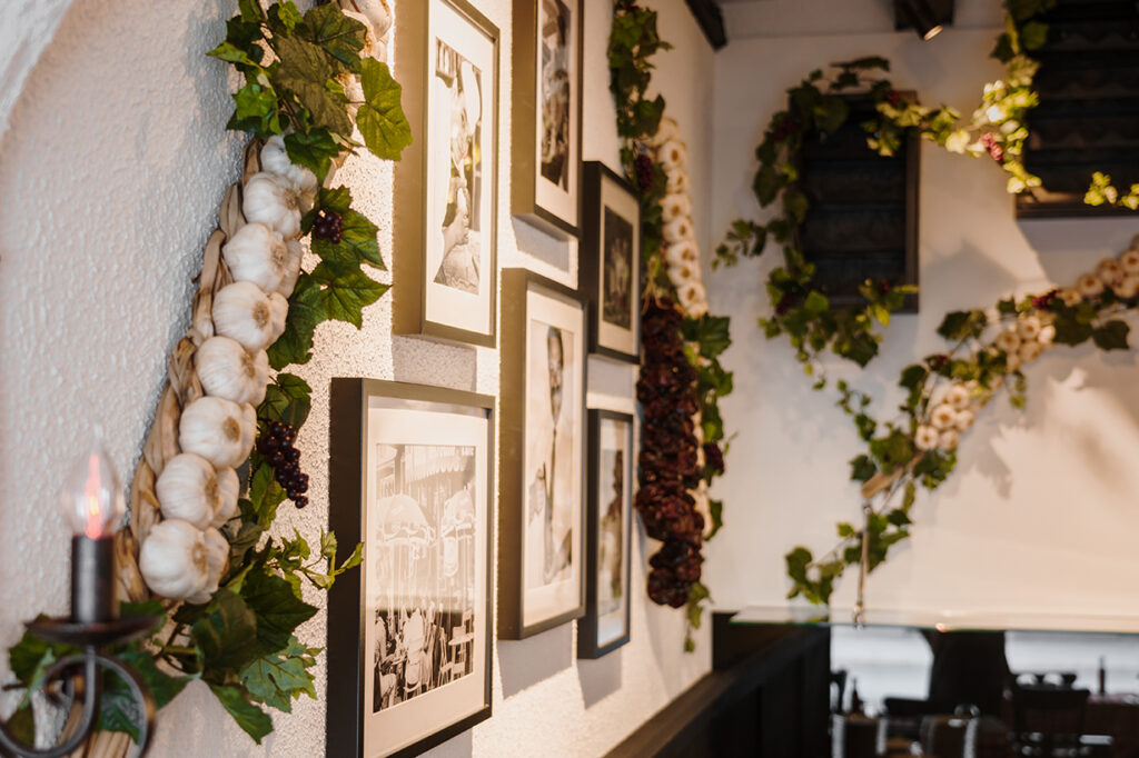 Ravintolan Denniksen sisätila, jossa seinällä on mustavalkoisia valokuvia ja köynnöskoristeita.