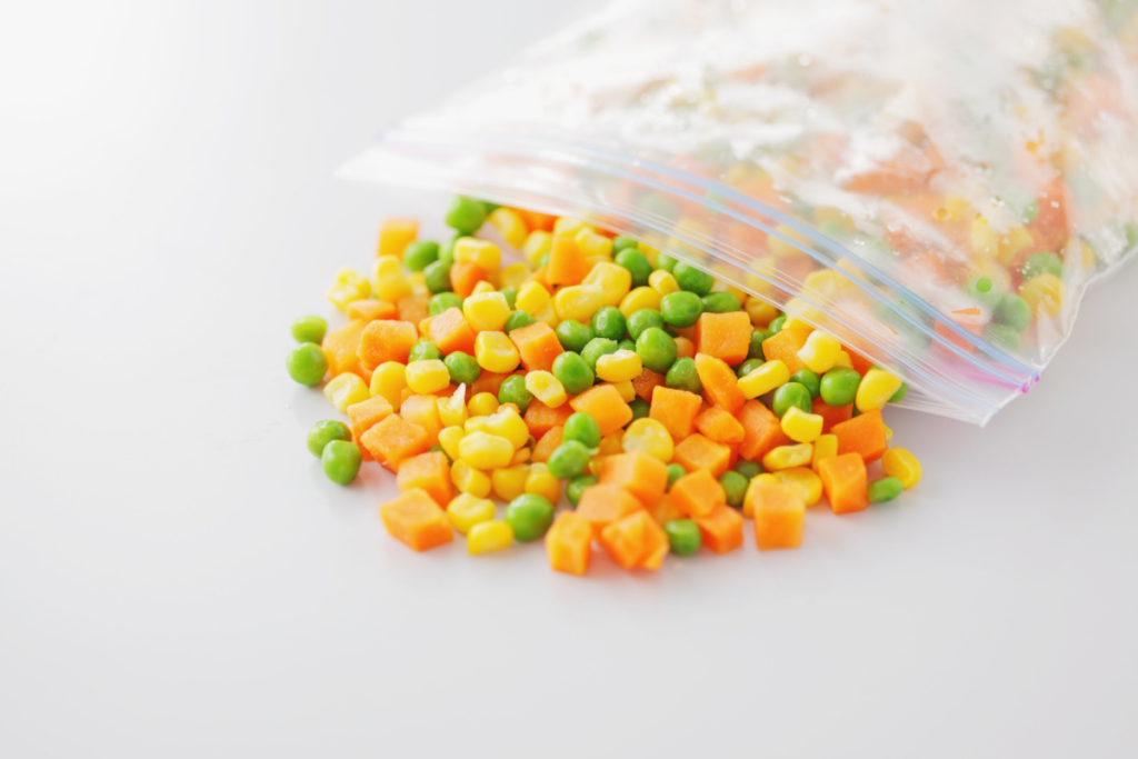 Pakastettu herne-maissi-porkkanapussi avoinna pöydällä.