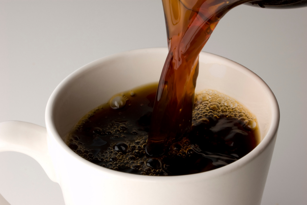 Kahvia kaadetaan kuppiin lähikuvassa.