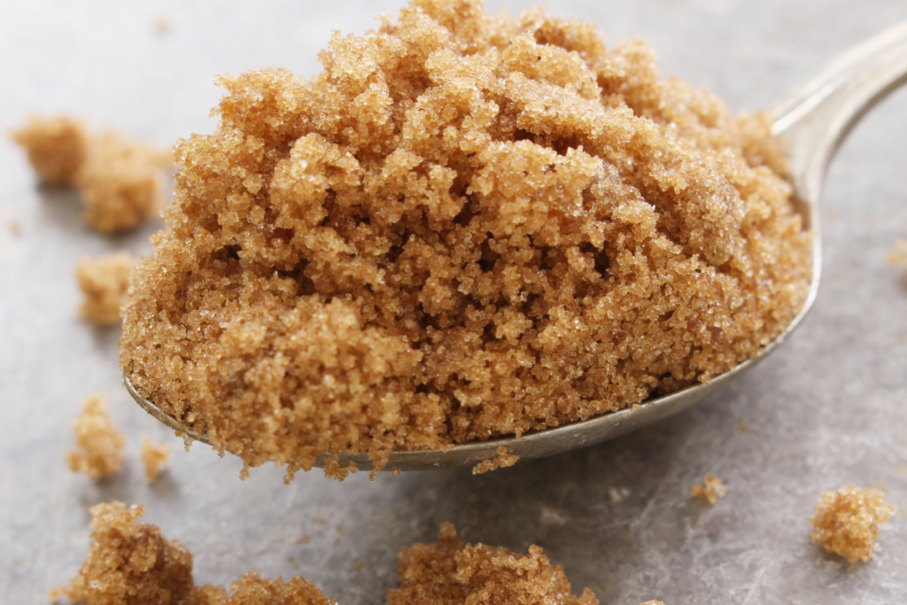 Lusikallinen fariinisokeria lähikuvassa vaaleaa taustaa vasten.